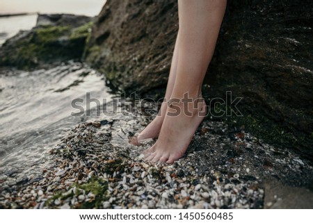 Female leg with silver decoration on the seashore