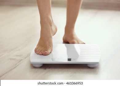 Female leg stepping on floor scales