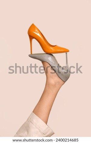 Female leg with stylish high heeled shoes on light background, closeup