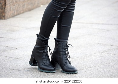 Female Legs In Black Jeans And Boots On High Heels. Slim Girl Standing On A Street, Fashion In Autumn City