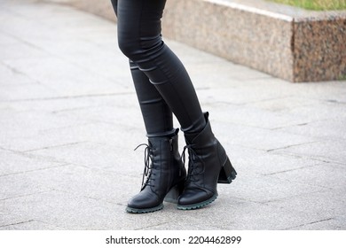 Female Legs In Black Jeans And Boots On High Heels. Slim Girl Standing On A Street, Fashion In Autumn City