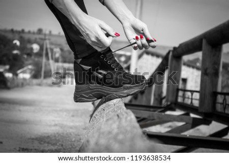 female legs in black sneakers outside