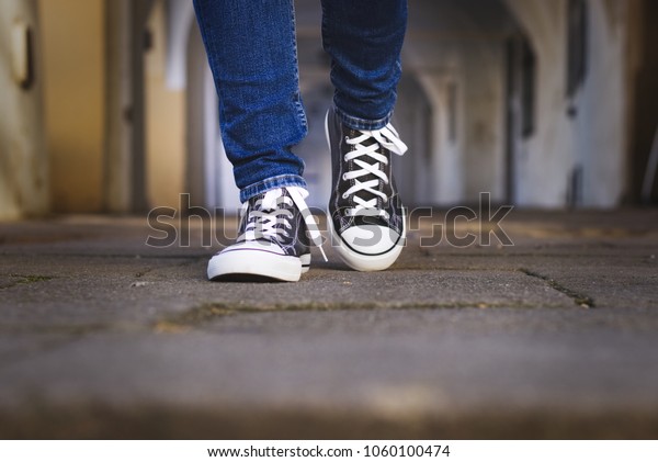 ズックスの靴をはいた女の脚がくものの通りを歩く 古い町を歩くスニーカー姿のおしゃれな女性 の写真素材 今すぐ編集