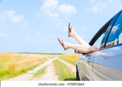 Female Legs Dangling From The Open Car Window In The Shales