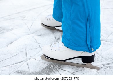 Female Legs Are In Figure Skates On Lake Ice, Close Up View