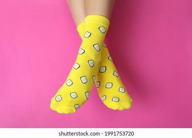 Female legs in funny socks on pink background