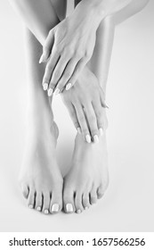 Female legs, hands, perfect skin, fresh manicure, pedicure. Foot care body care concept. Black and white
