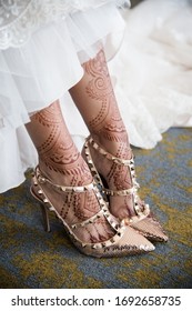 Female Legs With Henna Tattoo. Indian Bride's Showing Mehndi Design.  Mehndi Feet In Beautiful Female Wedding Bride Shoes With Mehndi Tattoos. Indian Tradition. 