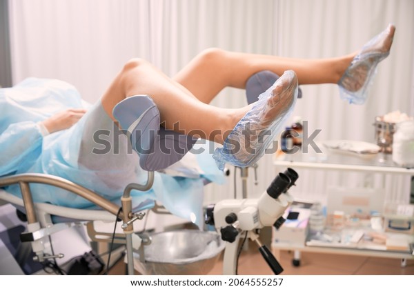 Female legs in medical shoe covers in\
gynecological chair near colposcope. Woman waiting for\
gynecological examinations in modern medical center. Concept of\
gynecology, obstetrics and female\
health.