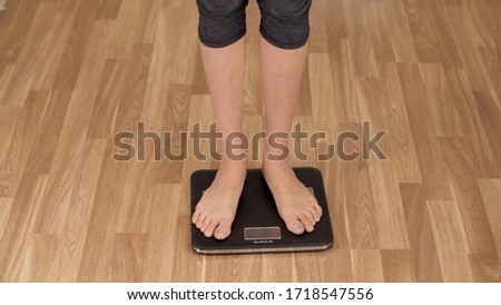 Female legs on the scales measure weight. Woman loses weight or gets fat during quarantine. Woman checking BMI weight loss. Human barefoot measuring body fat overweight.