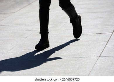 Female Legs On Sidewalk, Shadow Of Running Girl On City Street