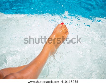 Female legs in the pool water selective focus and motion blur