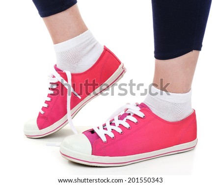 Female legs in sneakers isolated on white