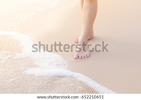 Female legs stand at the beach