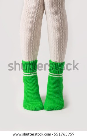 Female legs in white stockings and green knitted socks