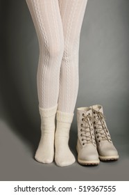 Female Legs In White Tights And Bright Winter Boots.