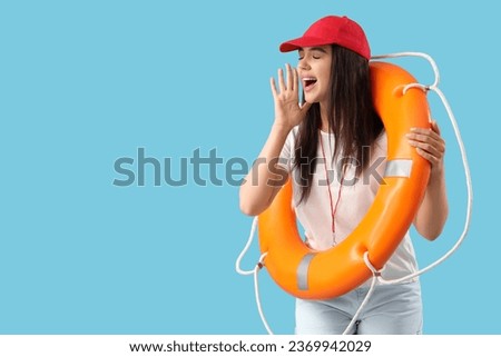 Female lifeguard with ring buoy shouting on blue background