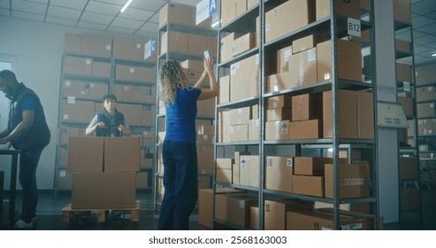 Female logistics specialist scans code on cardboard box using smartphone. Male warehouse worker loads parcel on pallet truck. Multiethnic warehouse employees working in logistics distribution center.