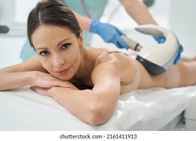 Female looking at camera while lying under vela shape therapy