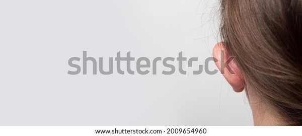 Female\
lop-eared protruding ear rear view on a light background.\
Otoplasty, plastic of the auricle. Banner.\

