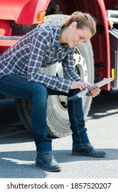 Female Lorry Driver Sat On Cab Step Looking At Clipboard