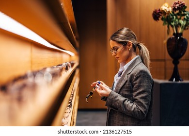 Female With A Low Ponytail, Looking For New Glasses.