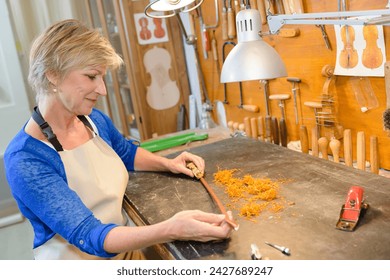 female luthier working on the creation of a violin - Powered by Shutterstock