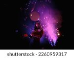 Female magician illusionist circus showing soap bubbles show at black background. Woman actress in theatrical clothes with stylish hat in stage costume. Concept of theatre performance. Copy space