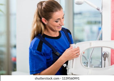 Female Maintenance Worker Checking The Quality Of A White Toilet Seat In The Showroom Of A Sanitary Ware Shop With Modern Fixtures And Accessories 