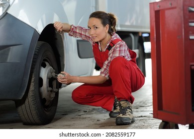 Female Maintenance Worker Putting Lubricant On Vehicle Rim