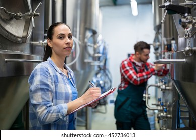 Female maintenance worker testing brewery machine at brewery - Powered by Shutterstock