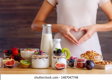 Female make shape of heart with her hands. Light summer breakfast with organic yogurts, fruits, berries and nuts. Nutrition that promotes good digestion and functioning of gastrointestinal tract. - Shutterstock ID 1487047748