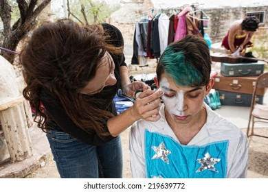 Female Makeup Artist Putting Makeup On Male Clown