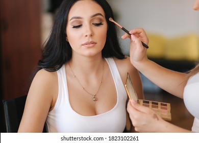 Female Makeup Master In Protective Medical Mask Use A Natural Brush. Beautiful Model In Beauty Studio. Professional Make Up Artist Finish Fashion Maleup. Makeup In Qurantine