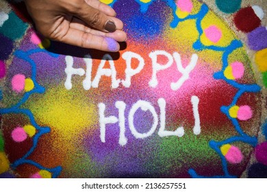 Female Making Beautiful And Colourful Happy Holi Rangoli Made At Home During Holi Festival. Holi Celebrations At House With Rangoli Colorful Powder. Rangoli Colours Kolam Art . Girl Making Rangoli.