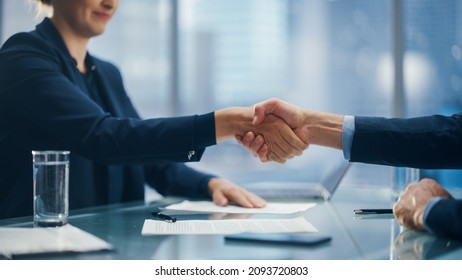 Female And Male Business Partners Sign Successful Deal Documents And Shake Hands In Meeting Room Office. Corporate CEO And Investment Manager Handshake On A Lucrative Financial Opportunity.