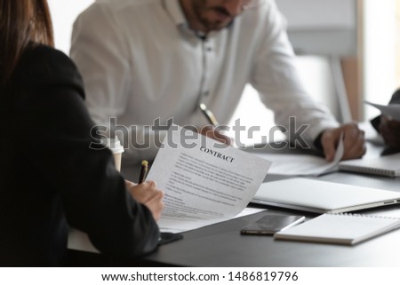 Female and male business partners sign contracts at meeting negotiation, man and woman put written signature on legal papers fill document form make partnership agreement deal concept, close up view