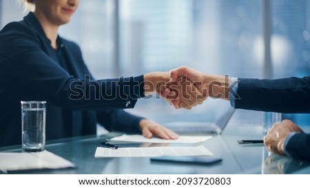 Female and Male Business Partners Sign Successful Deal Documents and Shake Hands in Meeting Room Office. Corporate CEO and Investment Manager Handshake on a Lucrative Financial Opportunity.