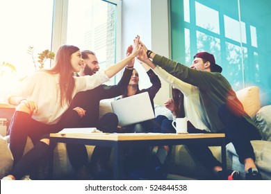 Female and male classmates celebrating pathing math examination, feeling exciting and cheerful , giving high five during informal meeting in friendly atmosphere with modern laptop in coworking space