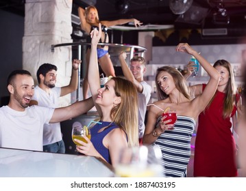 Female and male with cocktails dancing in the night club on party