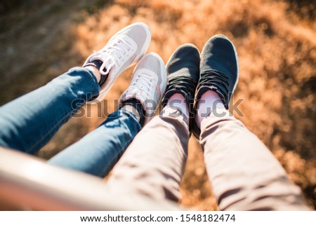 Female and male feet selfie on the top of the hill enjoying the view. Freedom concept. gold colour. gold leaves on the background.