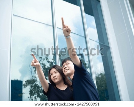 Female male man woman girl boy person people human beautiful pretty cheerful pointing finger gesture adult building tower city studio hand arm symbol portrait together teamwork set together couple