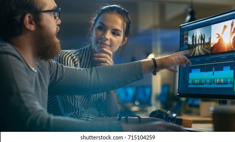 Female and Male Video Editors Work With Footage and Sound on Their Personal Computer with Two Displays. They are Beautiful and Creative People and Their Office is Modern Loft. - Shutterstock ID 715104259