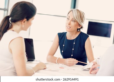 Female Manager Assessing Work Of Her Employees