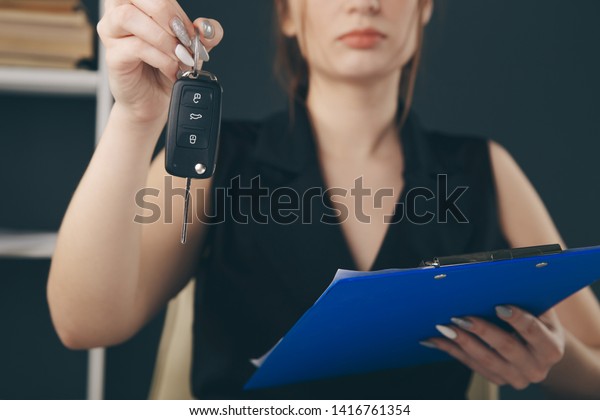 Female\
manager holding auto keys in office\
isolated.