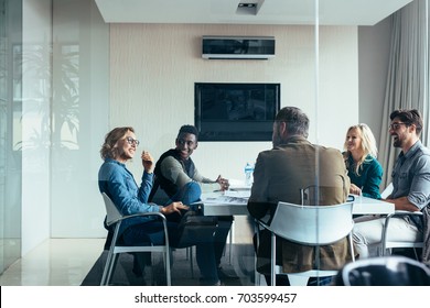 Female manager leads brainstorming meeting in design office. Businesswoman in meeting with colleagues in conference room. - Powered by Shutterstock