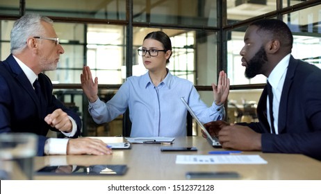 Female manager showing stop sign to arguing workers office, conflict resolution - Shutterstock ID 1512372128