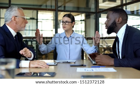 Female manager showing stop sign to arguing workers office, conflict resolution
