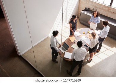 Female Manager In Team Meeting, Elevated View Through Window