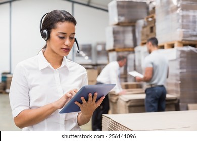 Female manager using digital tablet in warehouse